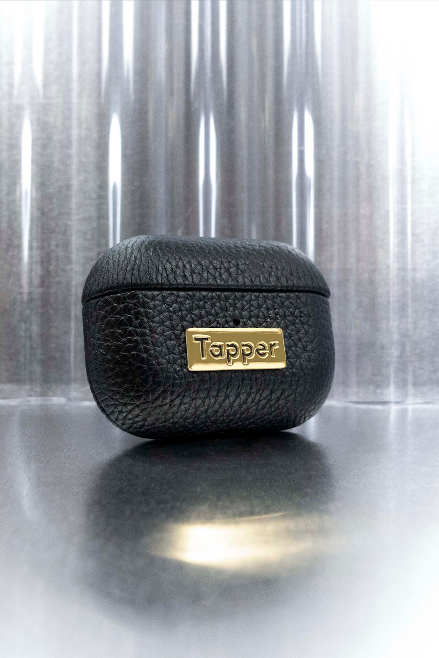 Tapper's luxurious black genuine cow leather AirPods case protects and elevates the look of your AirPods Pro. The luxurious, protective case for AirPods Pro with a metal logo plate in real 18k gold plating steps up your AirPods game. The next must-have high end protective Apple AirPods accessory in real leather and precious metals. Compatible with AirPods Pro. Designed in Sweden by Tapper. Free Express Shipping at gettapper.com