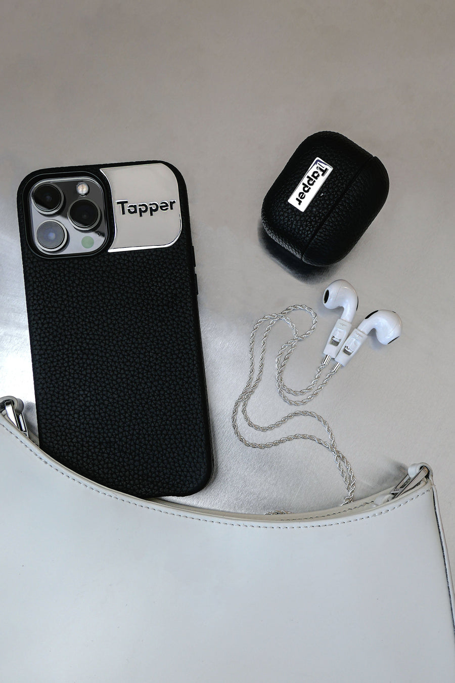 Tapper's luxurious black genuine cow leather iPhone 13 Pro Max case with MagSafe and a metal logo plate colored in silver that protects and elevates the look of your iPhone 13 Pro. The next must-have high end protective Apple iPhone accessory in real leather and metal details. Designed in Sweden by Tapper. Free Express Shipping at gettapper.com
