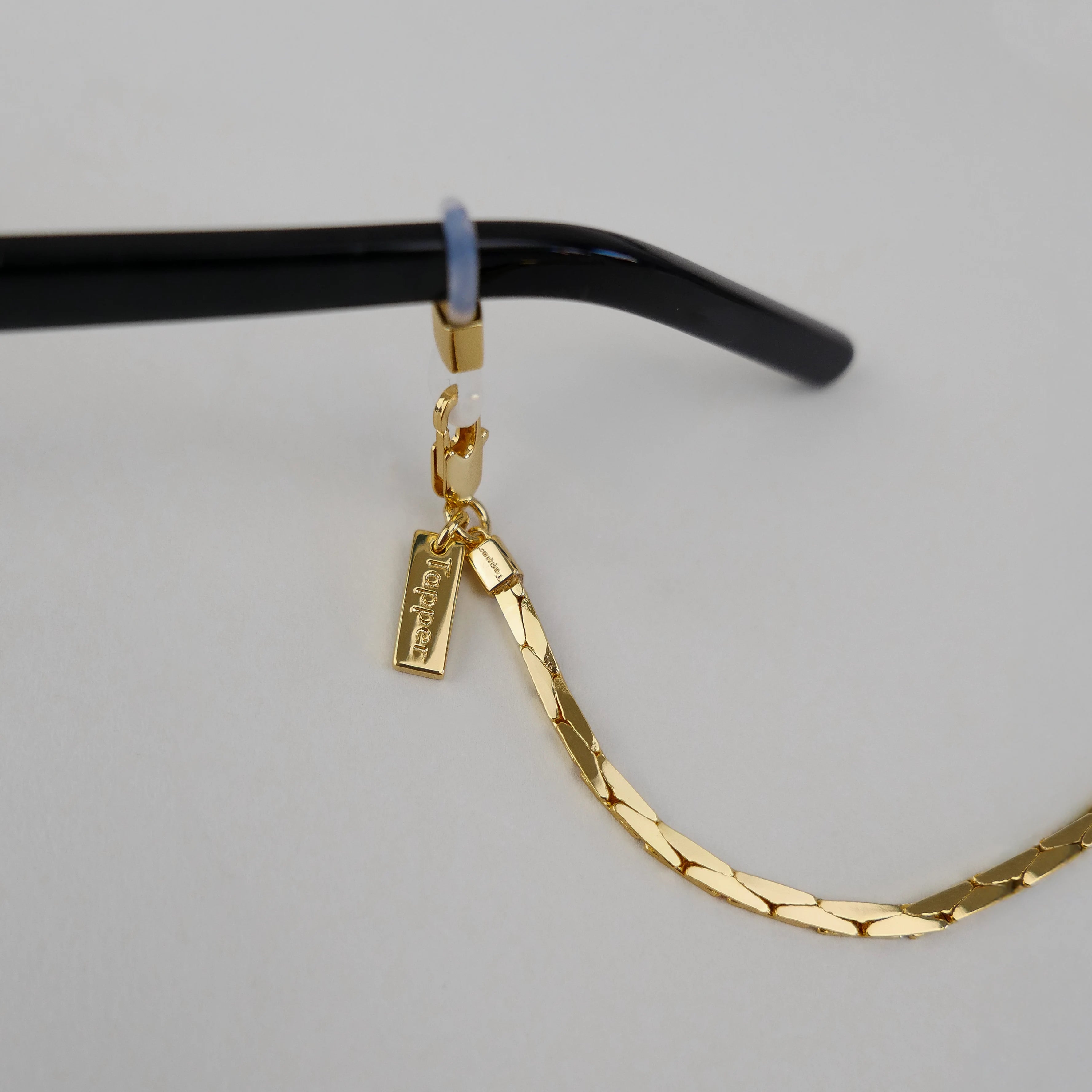 18K Gold Plated Glasses Chain by Tapper – Keep your eyewear secure and stylish with this elegant eyewear accessory. Designed in Sweden, this versatile chain fits eyeglasses and sunglasses, doubling as a necklace, bracelet, or body jewelry.