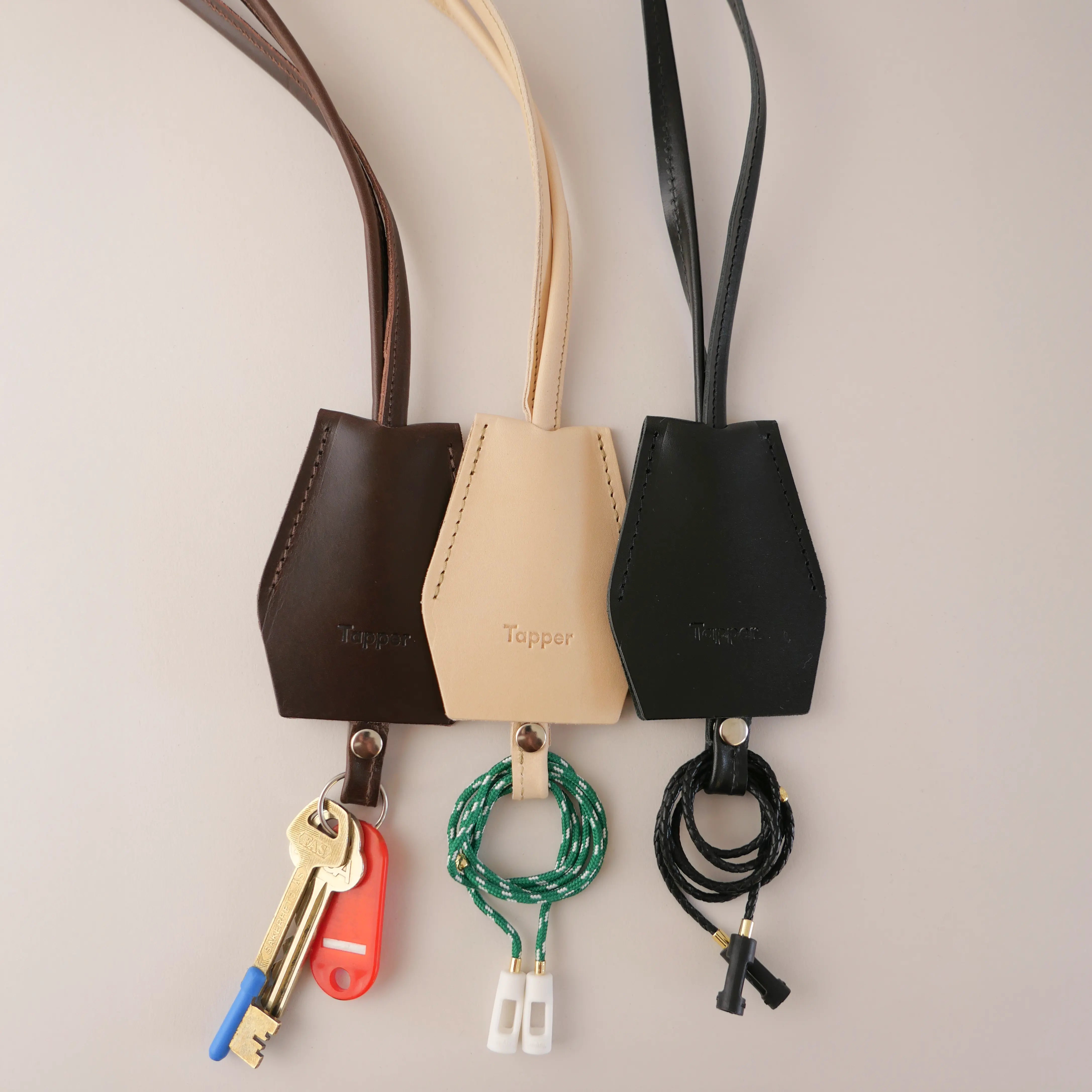 Handmade black leather AirPods strap and leather key holder with keychain and pouch ring, crafted in Sweden