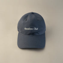 Tapper's Vacation Club cap in GOTS-certified organic cotton, featuring elegant embroidery — styled for summer with a chic, sunlit vibe, perfect for beach days, golden hours, and relaxed city strolls.