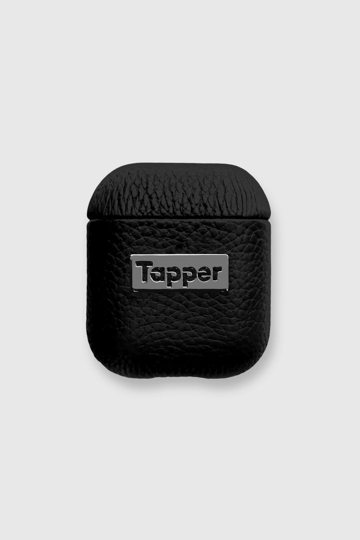 Tapper's luxurious black genuine lamb leather AirPods case protects and elevates the look of your AirPods. The luxurious, protective case for AirPods with a metal logo plate in hematite black plating steps up your AirPods game. The next must-have high end protective Apple AirPods accessory in real leather and precious metals. Compatible with AirPods (1st and 2nd generation). Designed in Sweden by Tapper. Free Express Shipping at gettapper.com