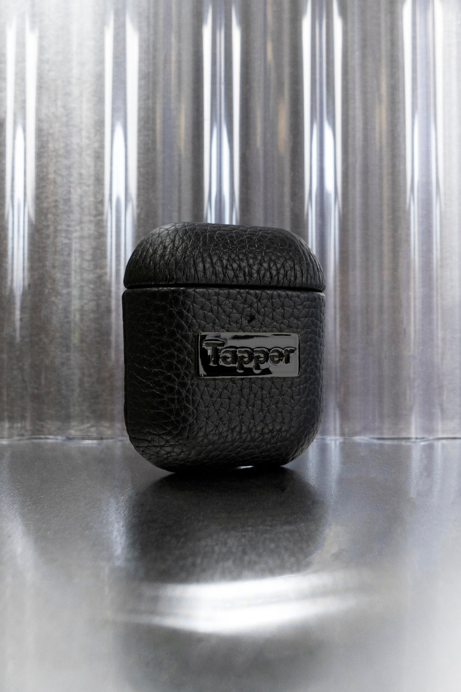 Tapper's luxurious black genuine cow leather AirPods case protects and elevates the look of your AirPods. The luxurious, protective case for AirPods with a metal logo plate in hematite black plating steps up your AirPods game. The next must-have high end protective Apple AirPods accessory in real leather and precious metals. Compatible with AirPods (1st and 2nd generation). Designed in Sweden by Tapper. Free Express Shipping at gettapper.com