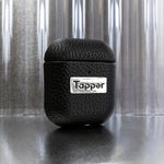 Tapper's luxurious black genuine cow leather AirPods case protects and elevates the look of your AirPods. The luxurious, protective case for AirPods with a metal logo plate colored in silver steps up your AirPods game. The next must-have high end protective Apple AirPods accessory in real leather and metal details. Compatible with AirPods (1st and 2nd generation). Designed in Sweden by Tapper. Free Express Shipping at gettapper.com