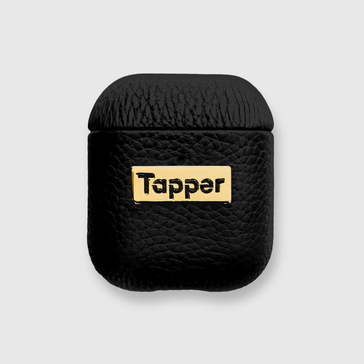 Tapper's luxurious black genuine lamb leather AirPods case protects and elevates the look of your AirPods. The luxurious, protective case for AirPods with a metal logo plate in real 18k gold plating steps up your AirPods game. The next must-have high end protective Apple AirPods accessory in real leather and precious metals. Compatible with AirPods (1st and 2nd generation). Designed in Sweden by Tapper. Free Express Shipping at gettapper.com