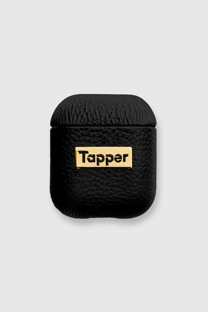 Tapper's luxurious black genuine lamb leather AirPods case protects and elevates the look of your AirPods. The luxurious, protective case for AirPods with a metal logo plate in real 18k gold plating steps up your AirPods game. The next must-have high end protective Apple AirPods accessory in real leather and precious metals. Compatible with AirPods (1st and 2nd generation). Designed in Sweden by Tapper. Free Express Shipping at gettapper.com