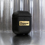 Tapper's luxurious black genuine cow leather AirPods case protects and elevates the look of your AirPods. The luxurious, protective case for AirPods with a metal logo plate in real 18k gold plating steps up your AirPods game. The next must-have high end protective Apple AirPods accessory in real leather and precious metals. Compatible with AirPods (1st and 2nd generation). Designed in Sweden by Tapper. Free Express Shipping at gettapper.com