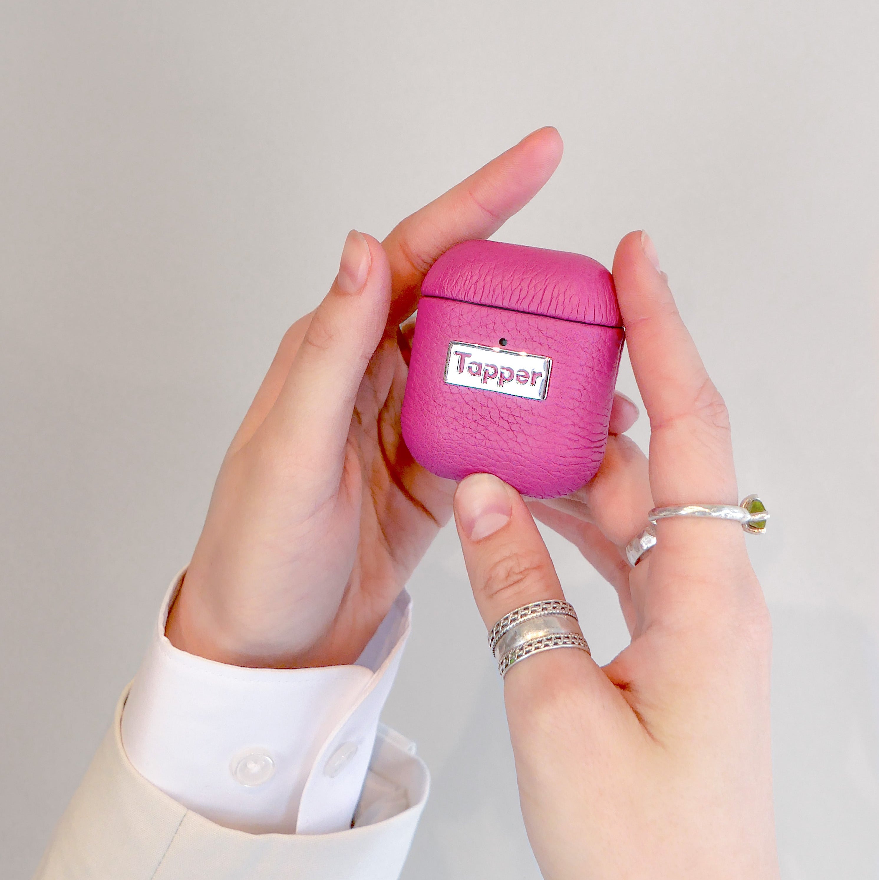 Tapper's luxurious hot pink genuine lamb leather AirPods case protects and elevates the look of your AirPods. The luxurious, protective case for AirPods with a metal logo plate colored in silver steps up your AirPods game. The next must-have high end protective Apple AirPods accessory in bright pink real leather and metal details. Compatible with AirPods (1st and 2nd generation). Designed in Sweden by Tapper. Free Express Shipping at gettapper.com