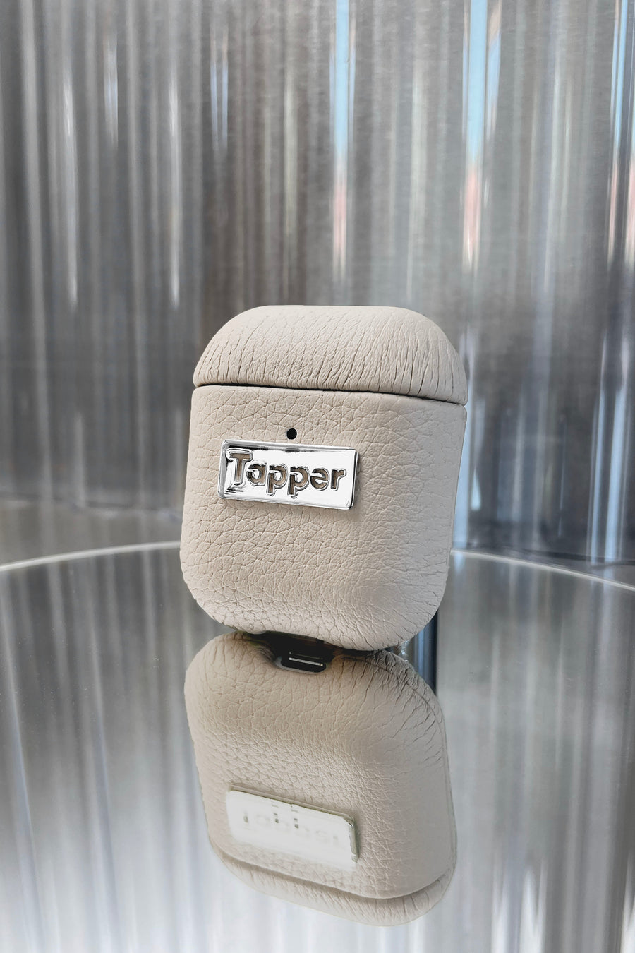 Tapper's luxurious sand beige genuine cow leather AirPods case protects and elevates the look of your AirPods. The luxurious, protective case for AirPods with a metal logo plate colored in silver steps up your AirPods game. The next must-have high end protective Apple AirPods accessory in real leather and metal details. Compatible with AirPods (1st and 2nd generation). Designed in Sweden by Tapper. Free Express Shipping at gettapper.com