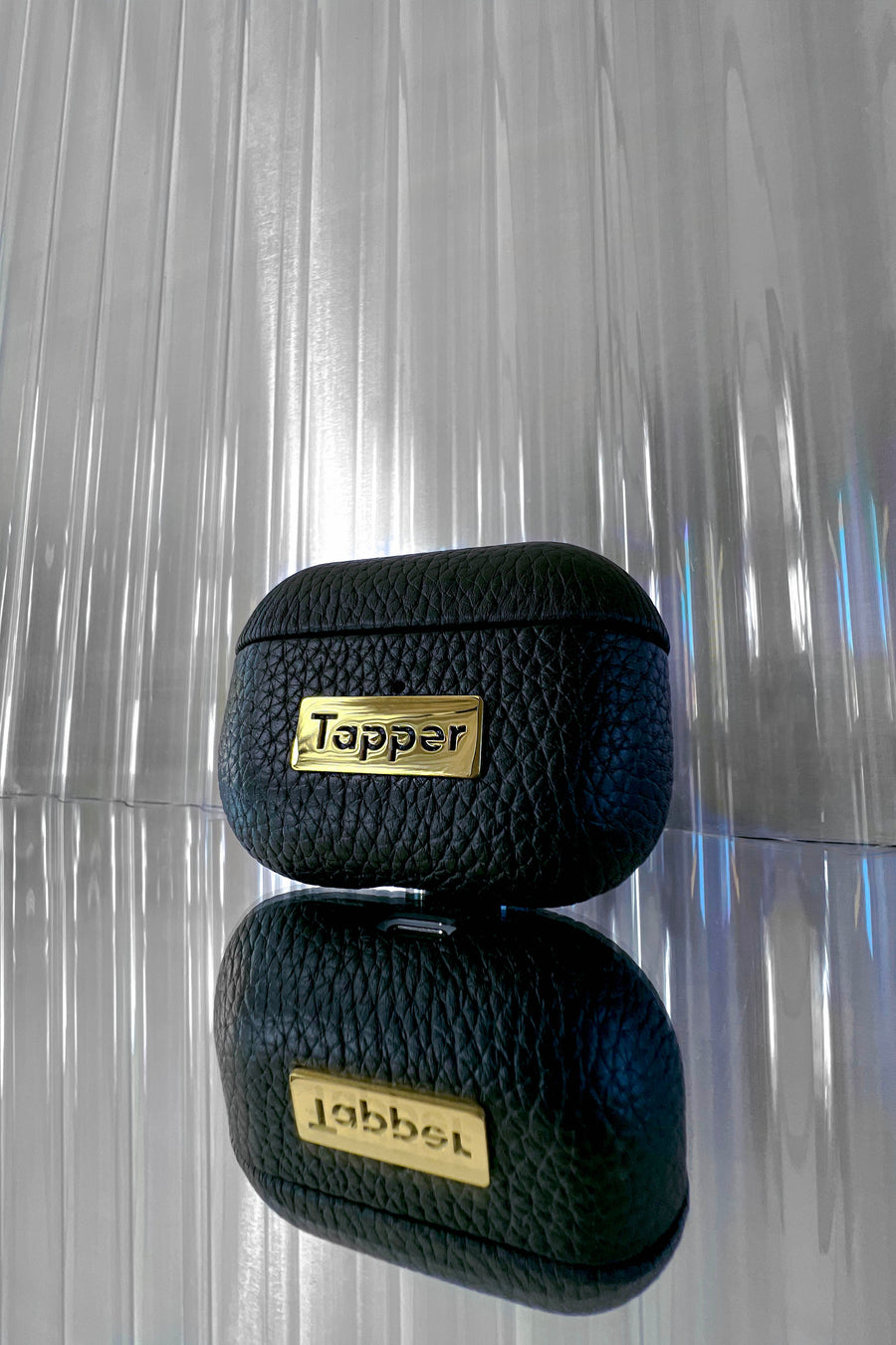 Tapper's luxurious black genuine cow leather AirPods case protects and elevates the look of your AirPods Pro. The luxurious, protective case for AirPods Pro with a metal logo plate in real 18k gold plating steps up your AirPods game. The next must-have high end protective Apple AirPods accessory in real leather and precious metals. Compatible with AirPods Pro. Designed in Sweden by Tapper. Free Express Shipping at gettapper.com