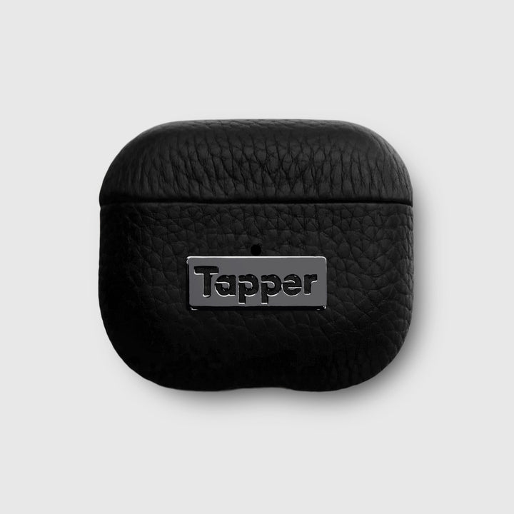 Tapper's luxurious black genuine lamb leather AirPods case protects and elevates the look of your AirPods. The luxurious, protective case for AirPods with a metal logo plate in hematite black plating steps up your AirPods game. The next must-have high end protective Apple AirPods accessory in real leather and precious metals. Compatible with AirPods (3rd generation). Designed in Sweden by Tapper. Free Express Shipping at gettapper.com