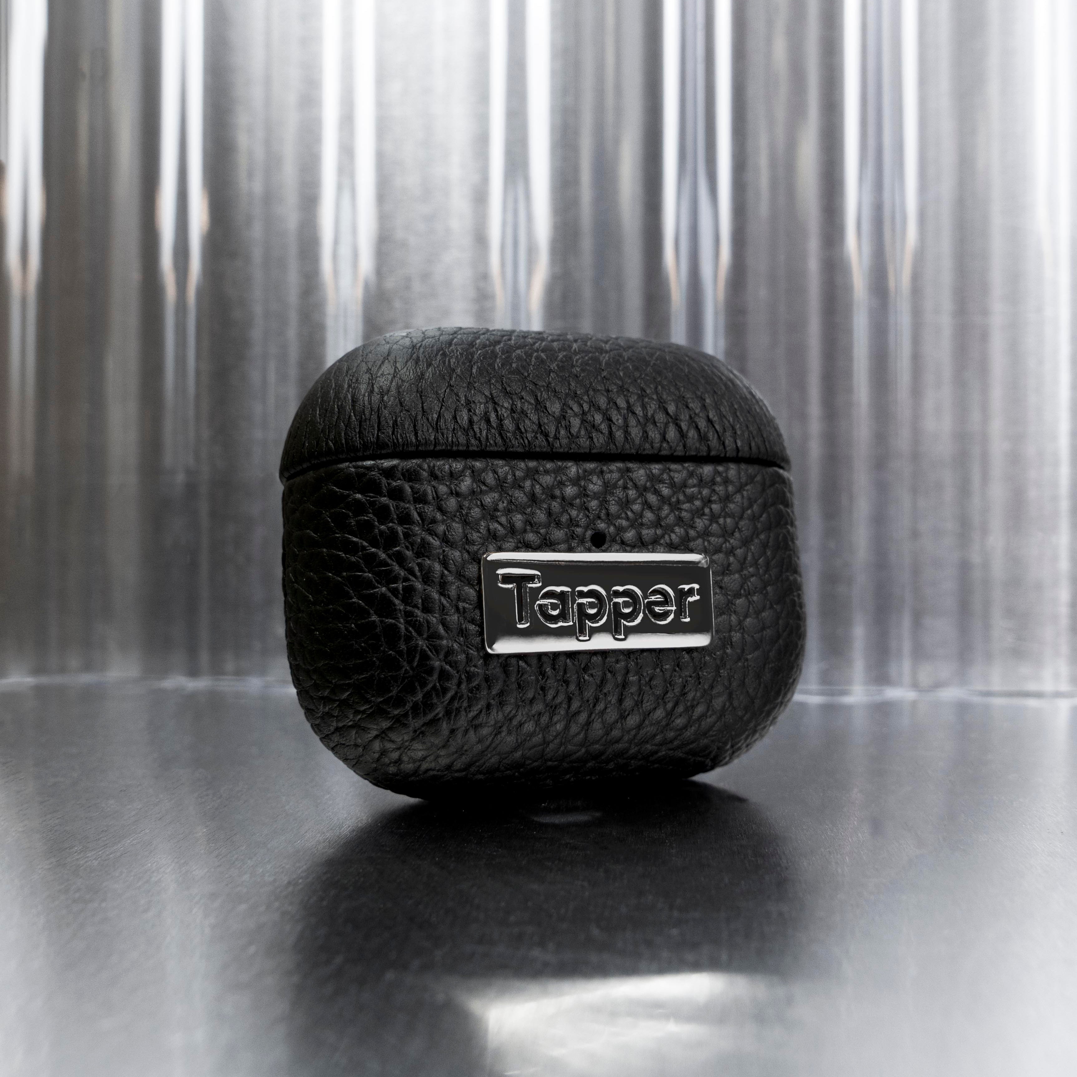 Tapper's luxurious black genuine cow leather AirPods case protects and elevates the look of your AirPods. The luxurious, protective case for AirPods with a metal logo plate in hematite black plating steps up your AirPods game. The next must-have high end protective Apple AirPods accessory in real leather and precious metals. Compatible with AirPods (3rd generation). Designed in Sweden by Tapper. Free Express Shipping at gettapper.com
