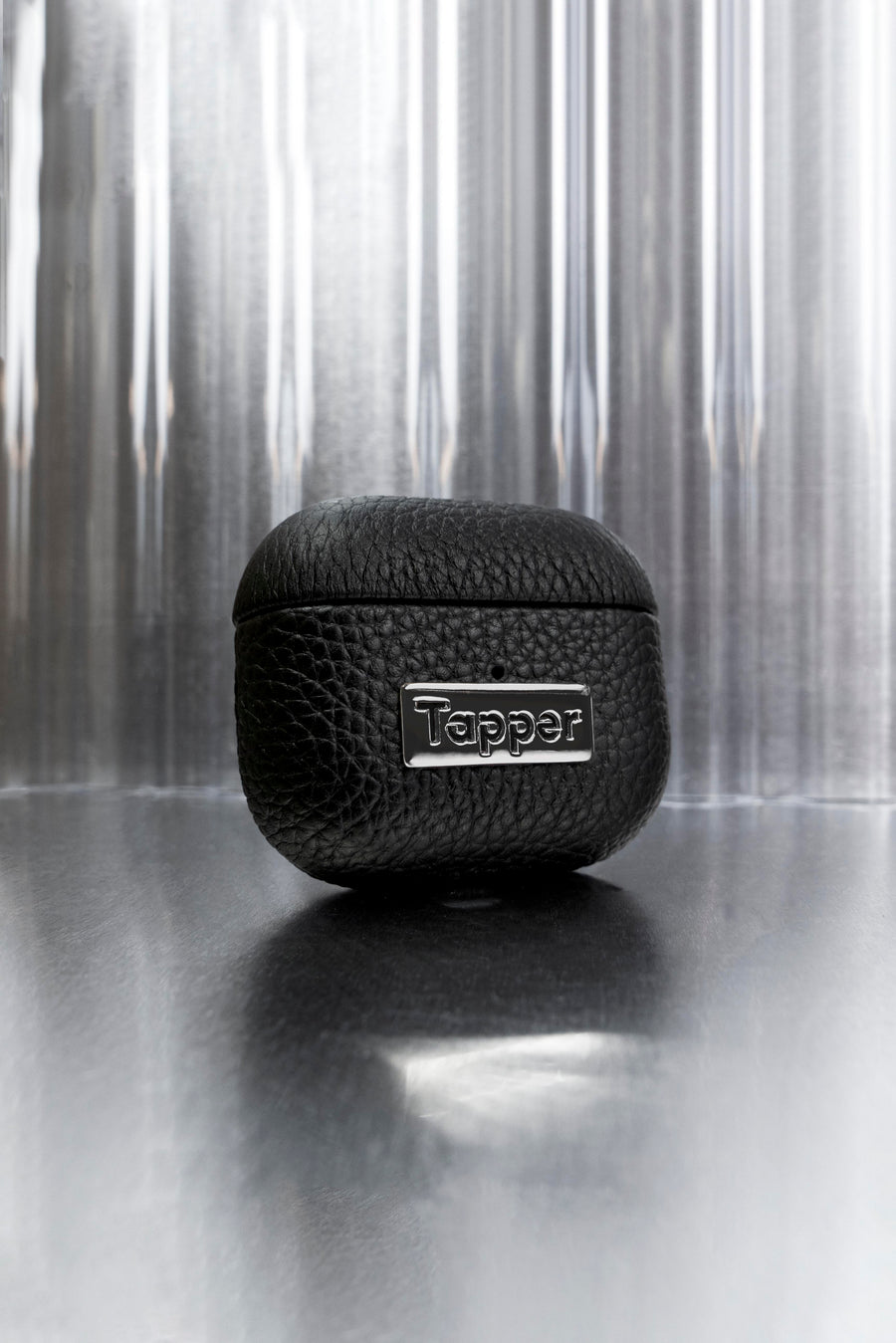 Tapper's luxurious black genuine cow leather AirPods case protects and elevates the look of your AirPods. The luxurious, protective case for AirPods with a metal logo plate in hematite black plating steps up your AirPods game. The next must-have high end protective Apple AirPods accessory in real leather and precious metals. Compatible with AirPods (3rd generation). Designed in Sweden by Tapper. Free Express Shipping at gettapper.com