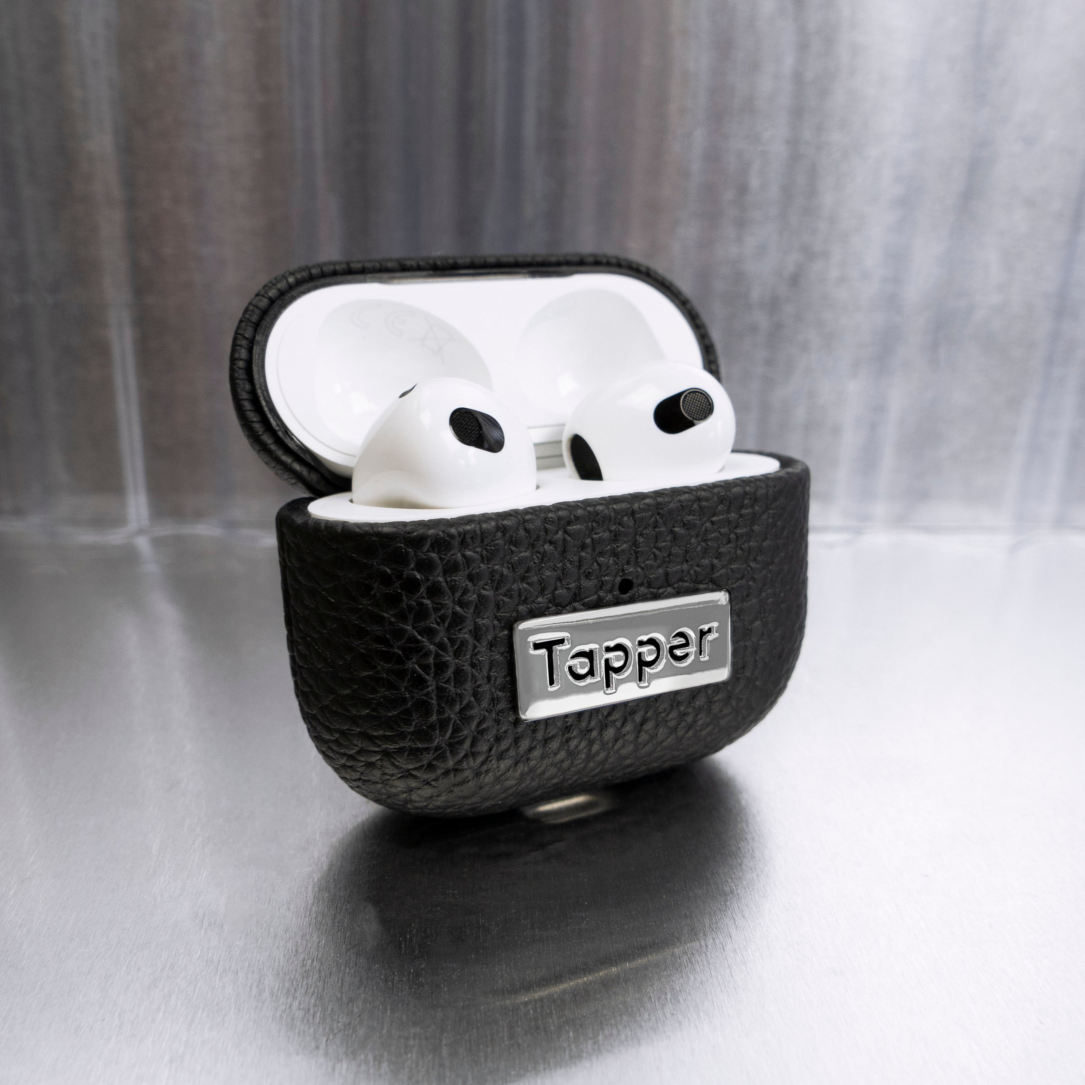 Tapper's luxurious black genuine cow leather AirPods case protects and elevates the look of your AirPods. The luxurious, protective case for AirPods with a metal logo plate colored in silver steps up your AirPods game. The next must-have high end protective Apple AirPods accessory in real leather with metal details. Compatible with AirPods (3rd generation). Designed in Sweden by Tapper. Free Express Shipping at gettapper.com